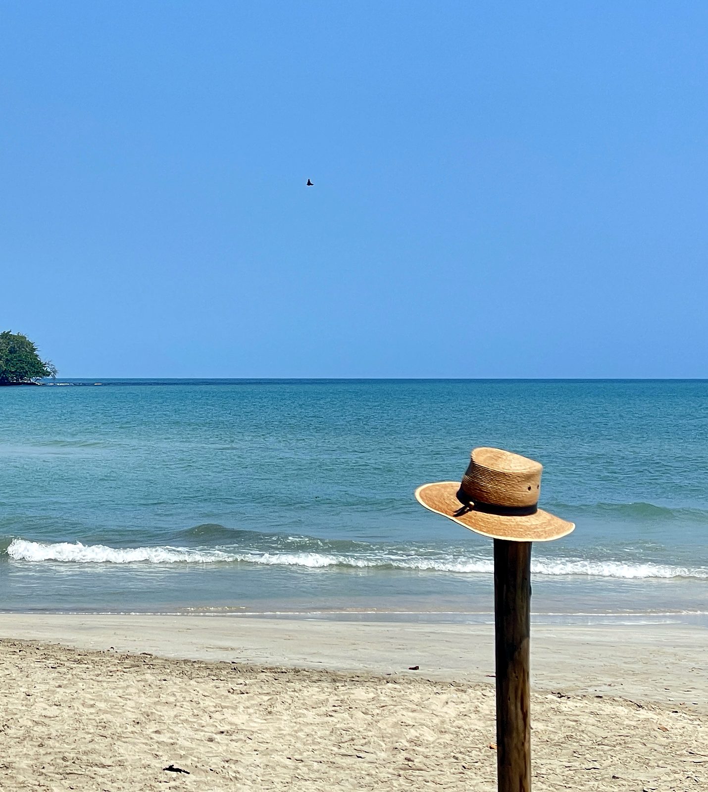 Um chapéu de palha num poste numa praia tranquila do lado caribenho da Costa Rica