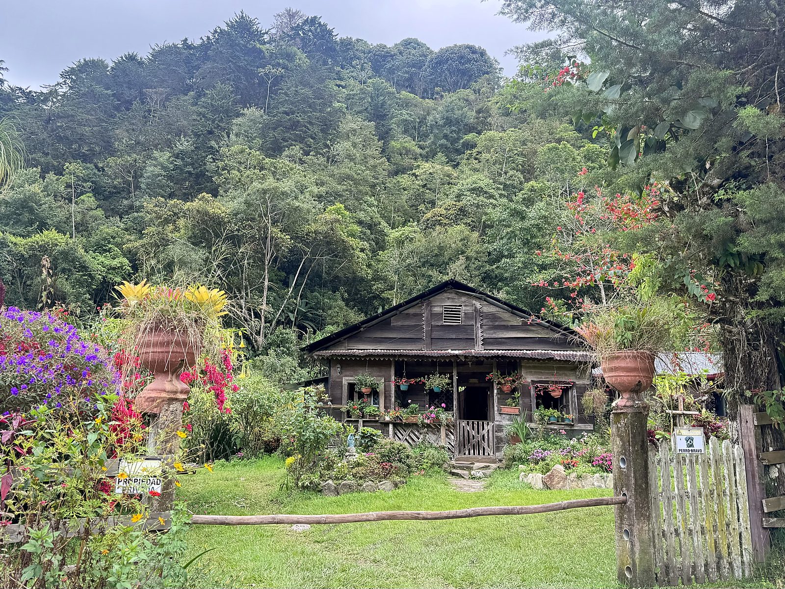 Uma casa de hospedagem de madeira com jardim florido na entrada do Parque Nacional Chirripó