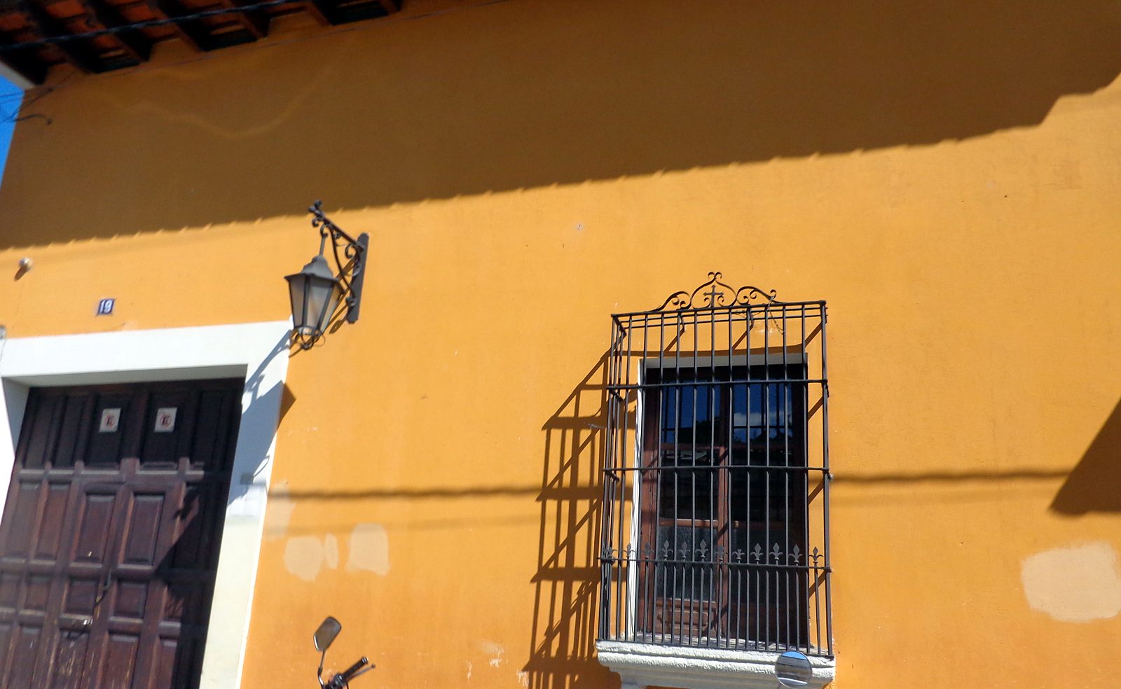 Una casa coloniale gialla con finestra in ferro ad Antigua Guatemala