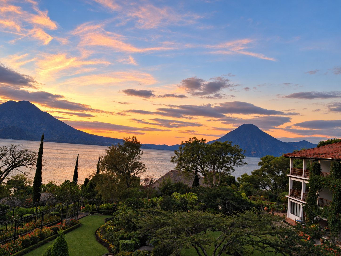 Il Lago Atitlán al tramonto con giardini e vulcani