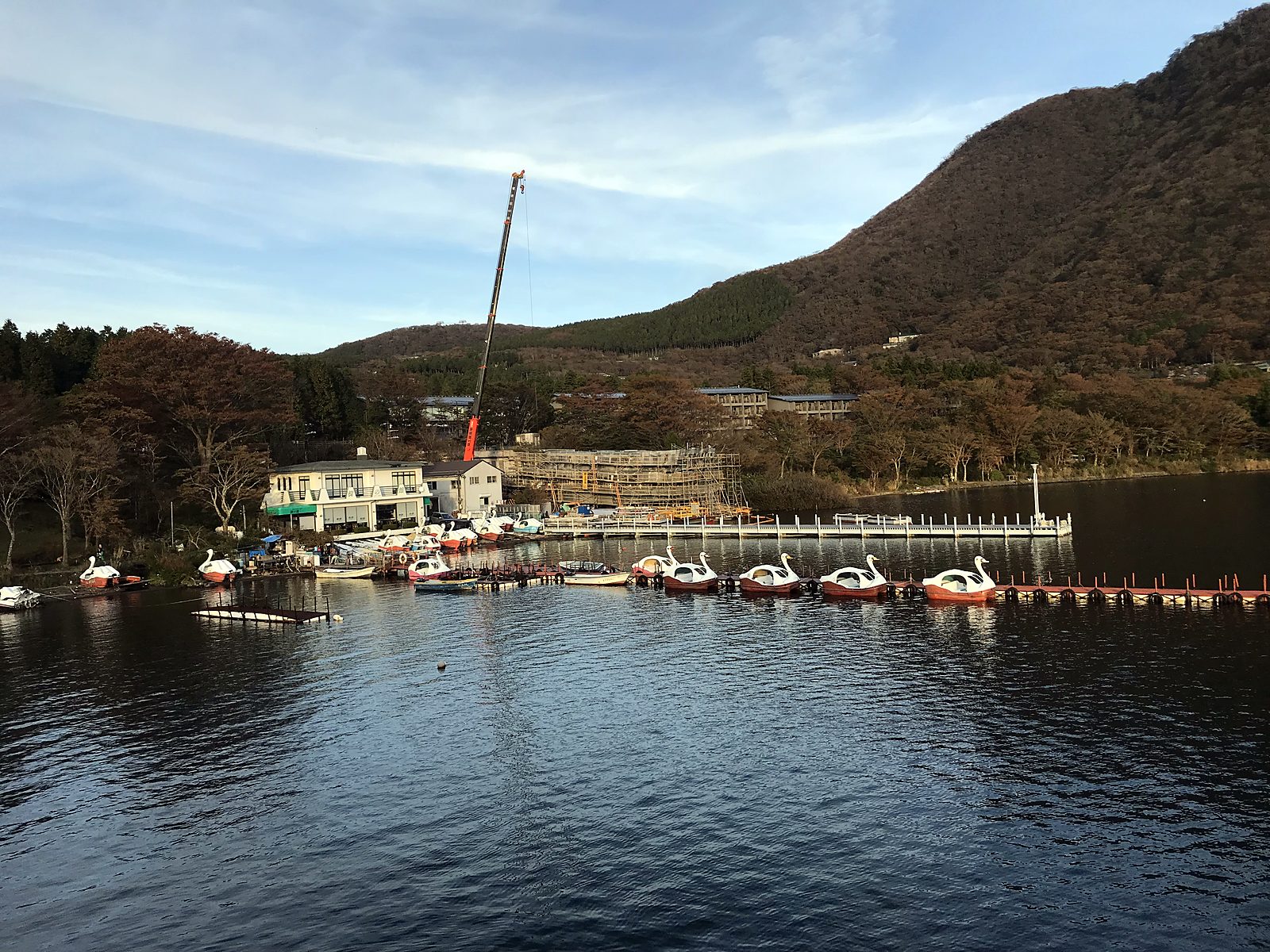 Un lago con barche e montagne verdi a Hakone