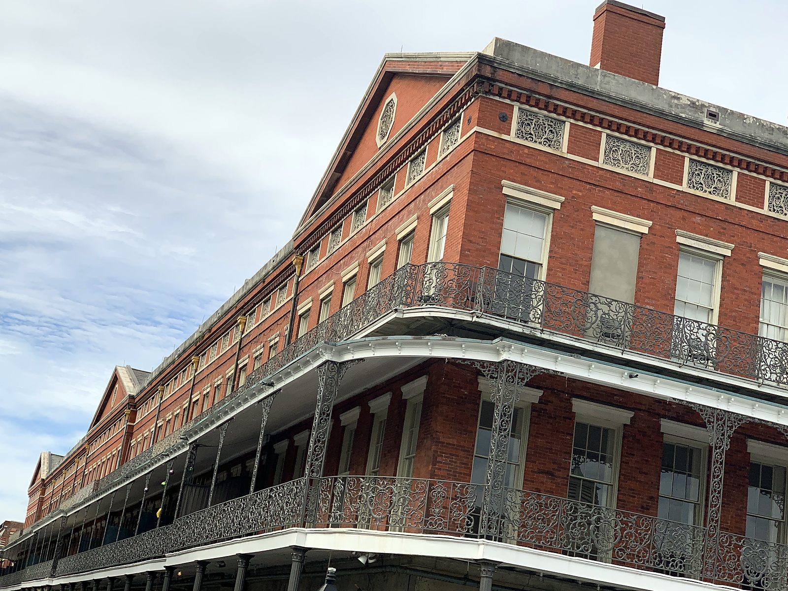 Edificio in mattoni rossi con lunghi balconi in ferro nel French Quarter