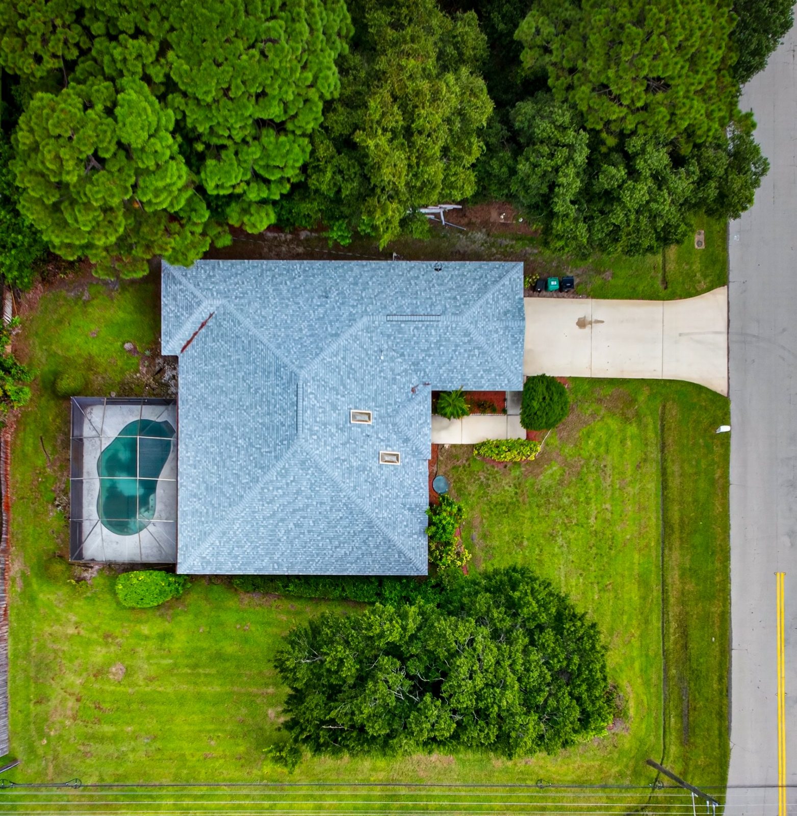 Vista aérea da casa e da piscina num lote de esquina